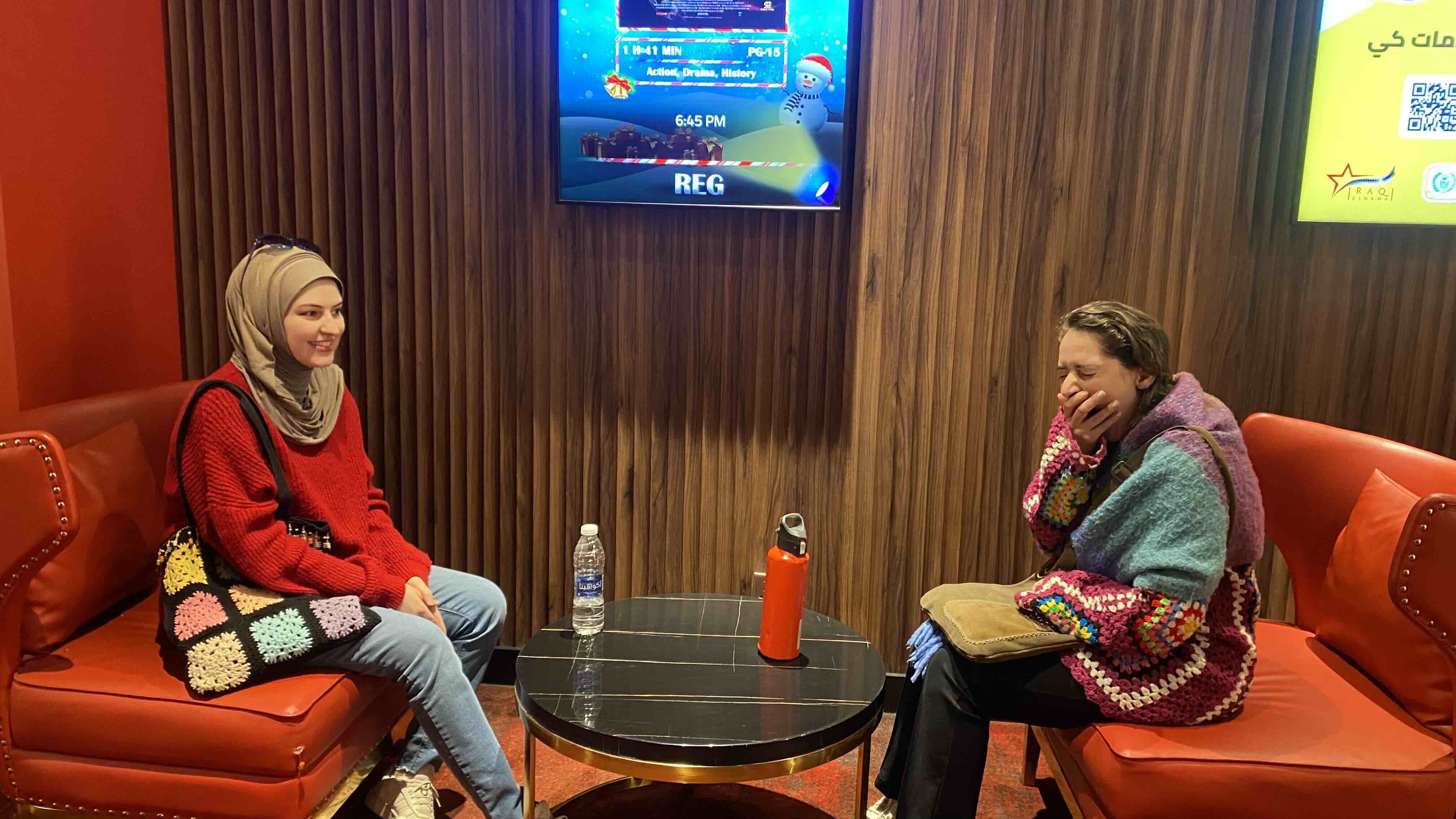 Mina and her sister, Reem, sitting outside the movie theater. Mina&rsquo;s yawning in the picture.